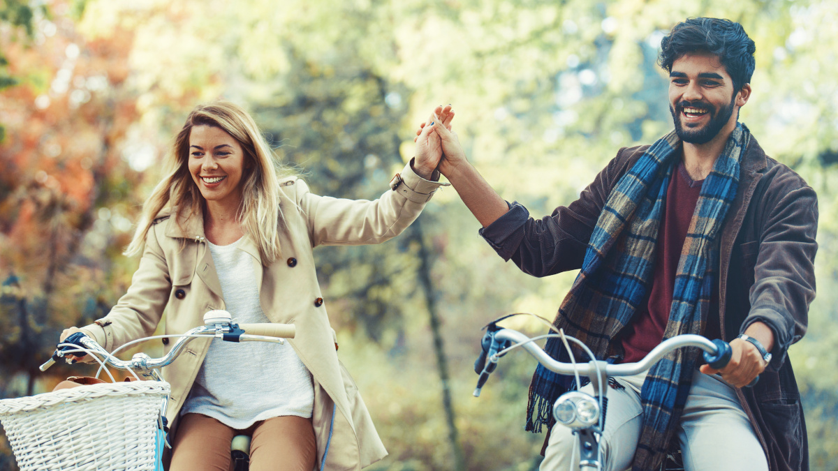 Active couple cycling in the forest in autumn