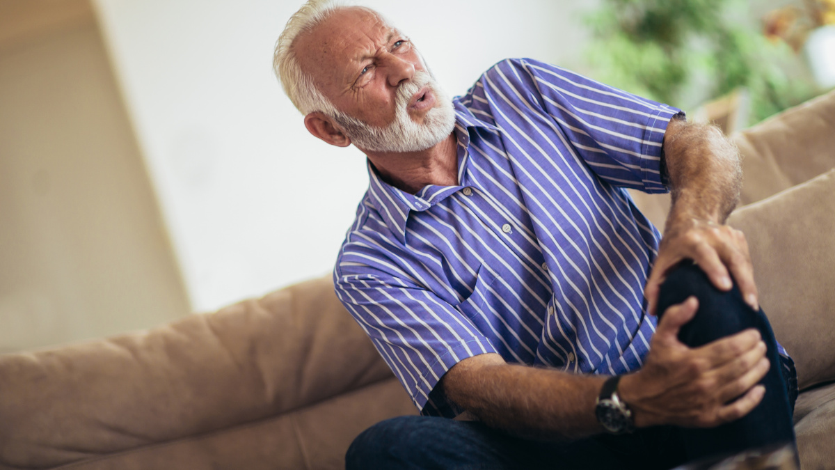 Vieil homme qui souffre de douleurs articulaires au genou