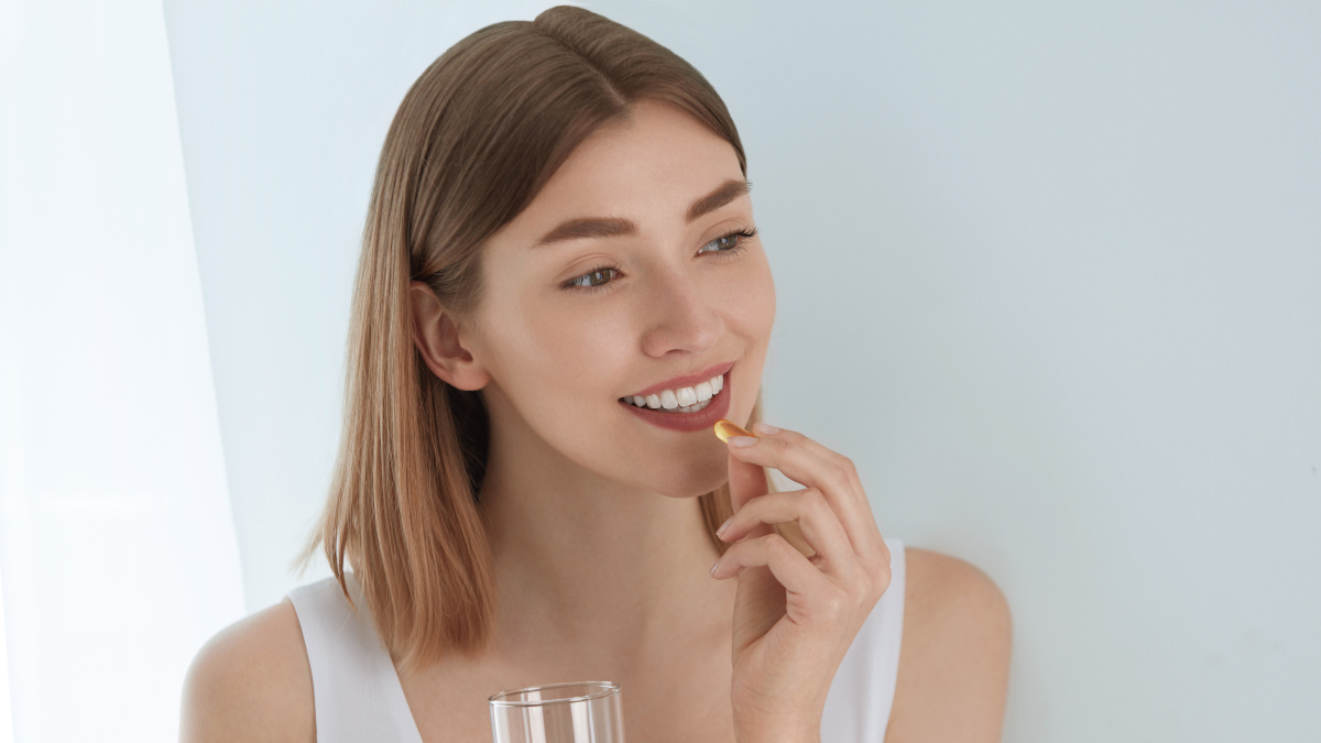 Woman taking a supplement for her skin