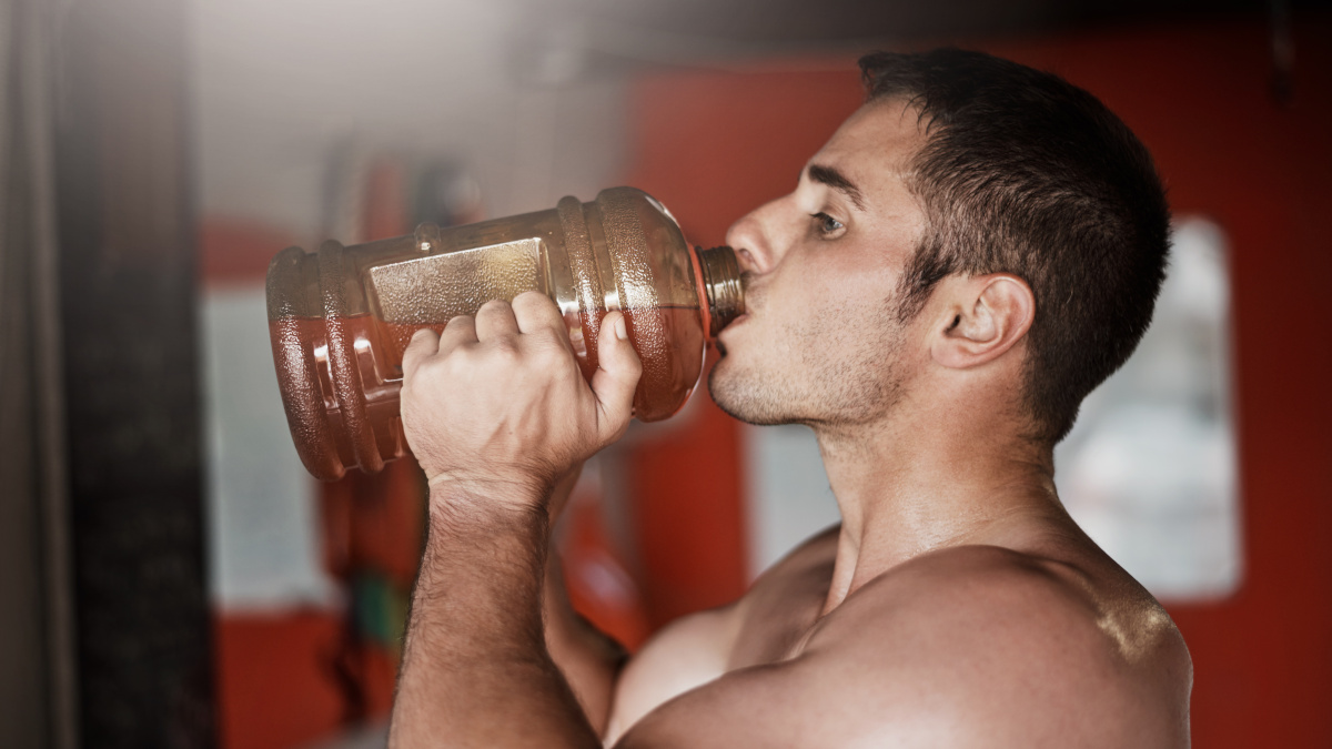 Culturista che beve una bevanda pre-allenamento fatta in casa